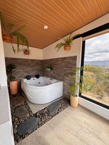 ein Bad mit einer Badewanne mit Pflanzen in der Unterkunft Glamping Eclipse Mirador Jarana Villa de Leyva 