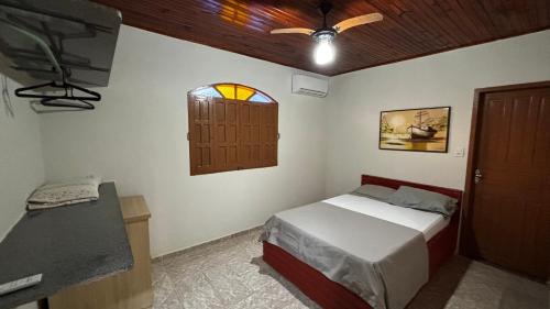 a bedroom with a bed and a window and a door at Casa Praia Guriri in São Mateus