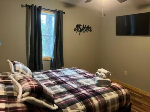 una camera da letto con un letto e una tv a parete di Sullivan Trail Cottage a Tannersville