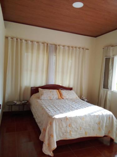 ein Schlafzimmer mit einem Bett mit weißer Bettwäsche und einem Fenster in der Unterkunft Finca Turistica Rancho Grande in Santana