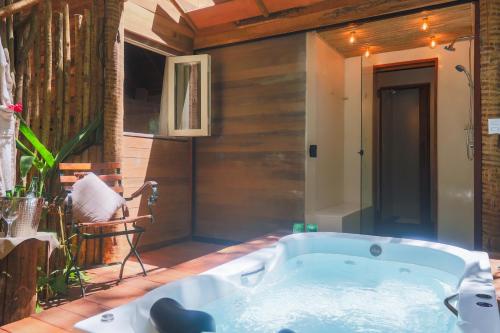a bathroom with a bath tub in a room at Casa das Oliveiras Pipa in Pipa