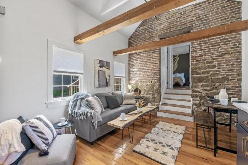 a living room with a couch and a brick wall at Broadway in Rockport