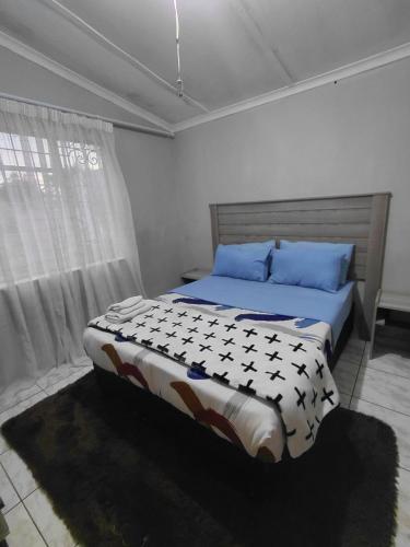 een slaapkamer met een groot bed met blauwe kussens bij Mama R's Hostel Life Experience in Newcastle