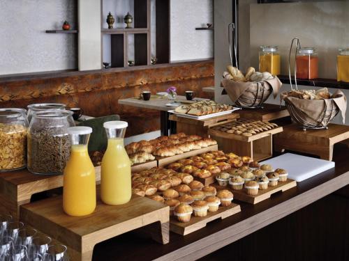 een buffet met gebak en flessen sinaasappelsap bij Mövenpick Hotel Apartments Downtown Dubai in Dubai