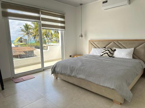 a bedroom with a bed and a large window at Suite Rosedelco in Puerto Villamil