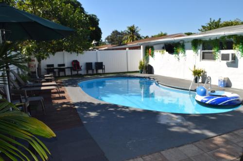 een zwembad met een vlot in een tuin bij Drip Star Life Hostel Miami in Parkway Regional Medical Center Heliport