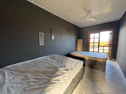 a bedroom with a large bed and a window at Casa com piscina in Tramandaí