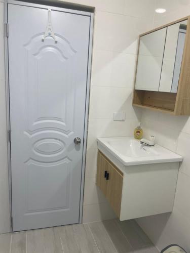 a bathroom with a white door and a sink at Mayra House habitación independiente cerca del aeropuerto las Américas TAXI DISPONIBLE in Andrés