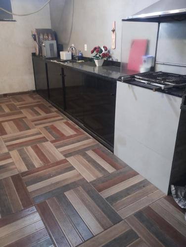 een keuken met een aanrecht en een houten vloer bij Litoral suítes in Araruama