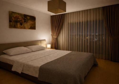 een slaapkamer met een groot bed en een raam bij London apartments 2 in Pristina