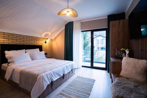 a bedroom with a large bed and a large window at Imperial Home Chalet in Sibiu