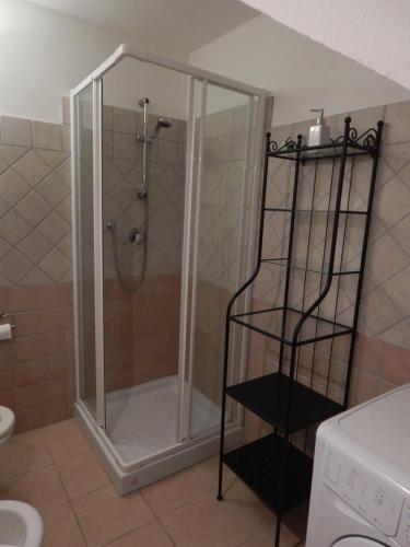 una doccia con porta in vetro in bagno di Villa A Schiera Porto Pozzo a Porto Pozzo