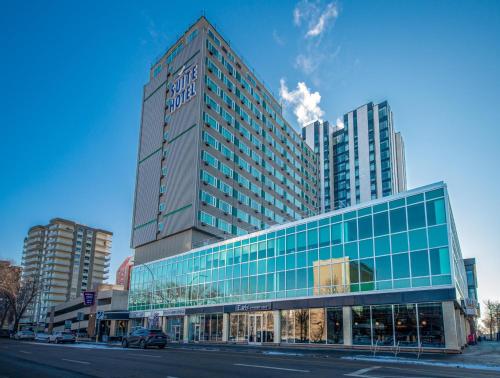 a tall glass building with a car parked in front of it at Campus Tower Suite Hotel in Edmonton