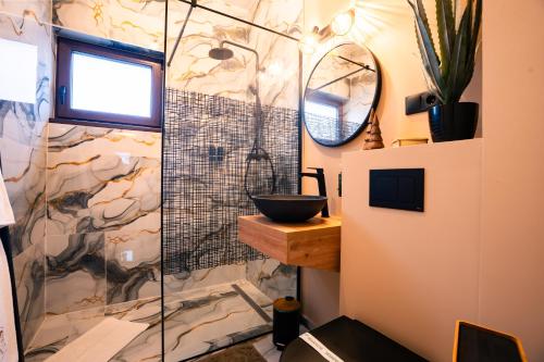 a bathroom with a glass shower with a sink at Imperial Home Chalet in Sibiu