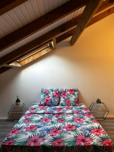 ein Schlafzimmer mit einem Bett mit geblümter Tagesdecke in der Unterkunft Bel Horizon in La Désirade