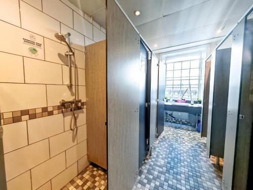 bagno con cabina doccia e pavimento piastrellato di Prime Backpackers Angel a Londra