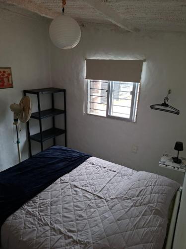 a bedroom with a bed and a window at La casa de Juan in Cuchilla Alta