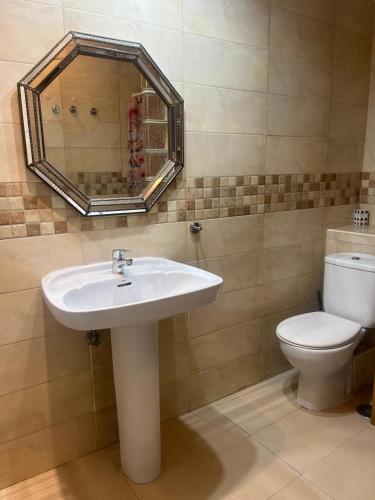 un bagno con lavandino, WC e specchio di Benidorm Apartament a Benidorm