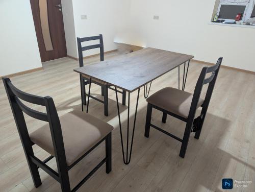 een eettafel met 2 stoelen en een houten tafel bij Home Sweet in Balaovit