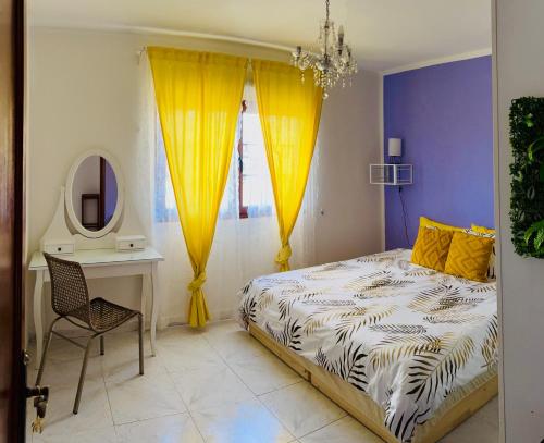 een slaapkamer met een bed, een bureau en een spiegel bij myplace in Tiagua