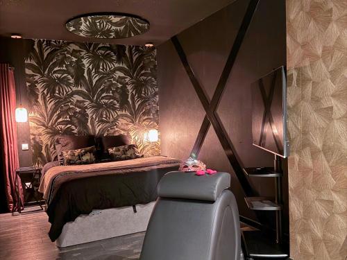 een slaapkamer met een bed en een koffer bij Hmm OH Oui - Studio With Sauna and More in Saint-Quentin