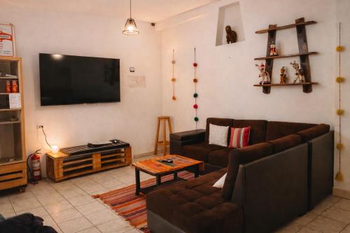 a living room with two couches and a flat screen tv at Shanti Hotel Pisac in Pisac