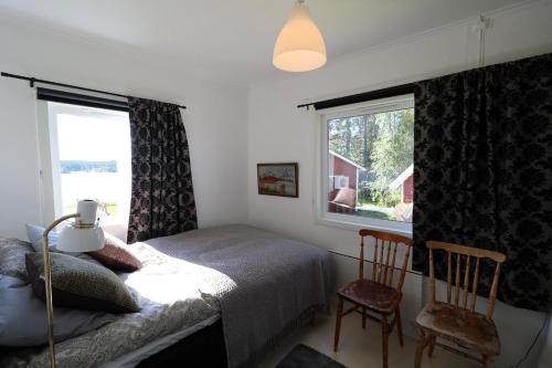 a bedroom with a bed and two chairs and a window at Aurora Jukkasjarvi in Jukkasjärvi