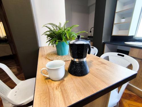 a coffee maker sitting on a wooden table with a cup at Laguna Apartment in Huaraz