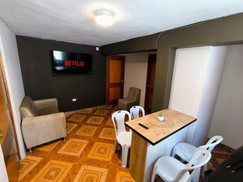 a room with a table and chairs and a television at Laguna Apartment in Huaraz