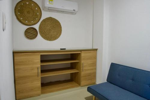 een woonkamer met een kast en een blauwe bank bij Gairaka 3 in Gaira