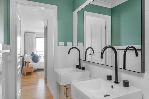 une salle de bain avec deux lavabos et deux miroirs dans l'établissement Panorama, Gerroa, South Coast, à Gerroa