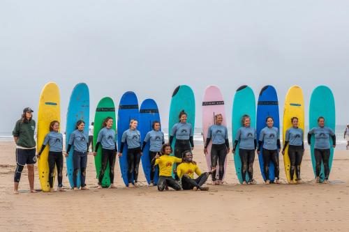 un gruppo di persone che si trovano di fronte alle tavole da surf di Mabidi Surf Taghazout a Taghazout