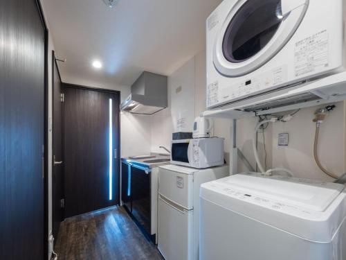 una piccola cucina con lavatrice e forno a microonde di Hote Io Lite a Nago