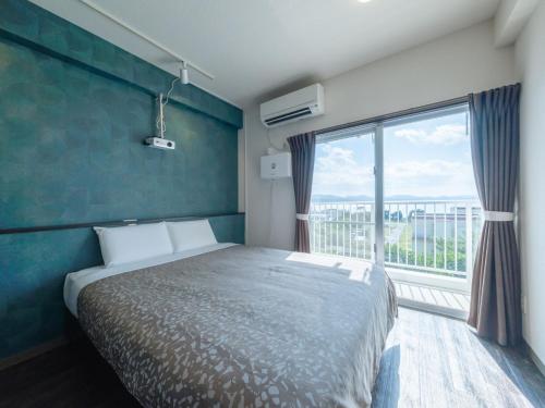 una camera da letto con un letto e una grande finestra di Hote Io Lite a Nago