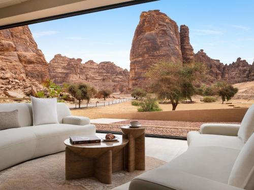 uma sala de estar com vista para as formações rochosas em Shaden Resort em Al Ula