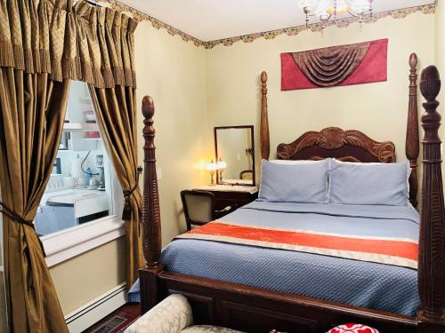 een slaapkamer met een bed en een raam bij Barkerhouse 2# unit-heart of oldtown in Niagara on the Lake