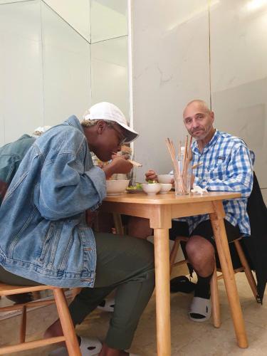 Een man en een vrouw die aan een tafel eten. bij Lavande Hue Homestay in Hue
