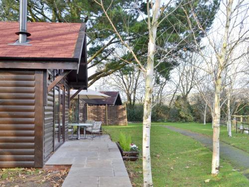 a house with a patio and a table in a yard at Blackberry Lodge in Cheddar