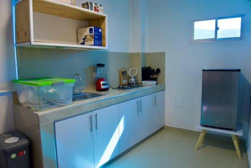 een keuken met een aanrecht met een wastafel en een koelkast bij Gairaka 5 in Gaira