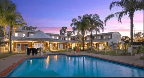 a house with a swimming pool in front of a house at 10 Sailz on the Murray in Yarrawonga