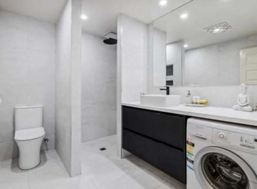 un bagno con lavatrice e lavandino di 10 Sailz on the Murray a Yarrawonga