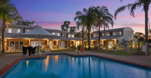 a house with a swimming pool in front of a house at 10 Sailz on the Murray in Yarrawonga