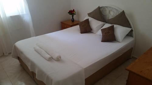 トゥルンチュにあるGökmen Apartmentsのベッドルーム1室(白いシーツと枕のベッド1台付)