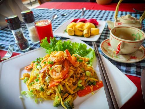 a plate of food with shrimp and vegetables on a table at Au Cabaret Vert in Battambang