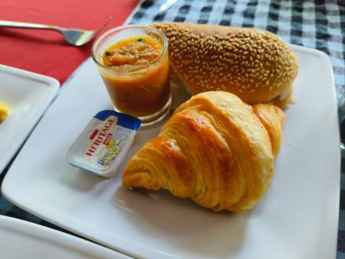 a plate of food with croissants and a drink at Au Cabaret Vert in Battambang