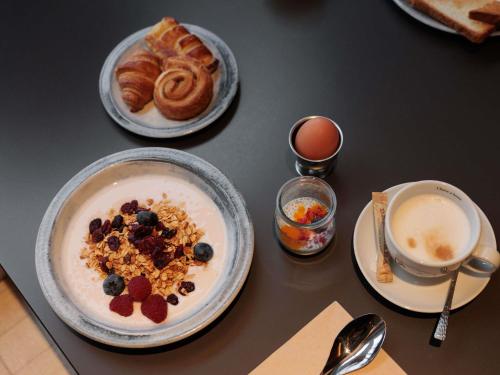 a table with two plates of breakfast food and a cup of coffee at Mercure Tallinn in Tallinn