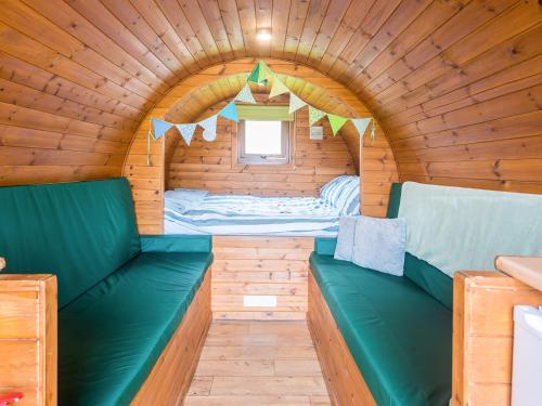 ein kleines Zimmer mit einem Bett in einem Holzhaus in der Unterkunft Rivendell Glamping Pod - Uk11881 in North Tamerton