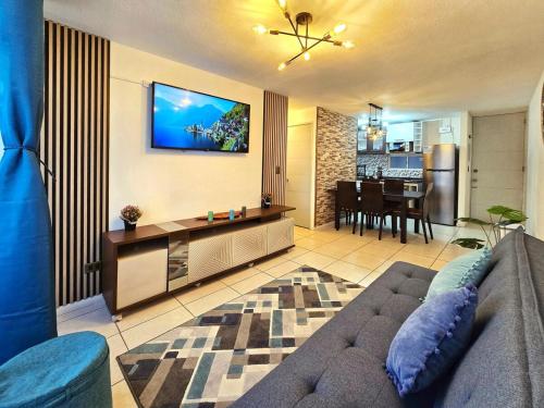 a living room with a couch and a tv on the wall at Oceanfront Vacation Pool WiFi Parking in Coquimbo