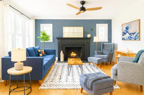 a living room with a blue couch and a fireplace at Profs Riverside Haven Art & Style Sleeps 10 in South Bend