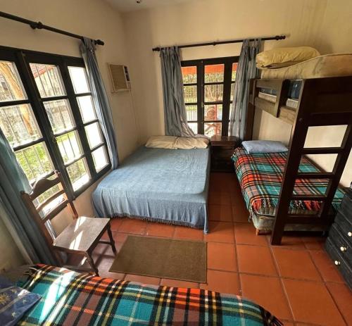 a room with two bunk beds and windows at La Gloria in Paso de la Patria